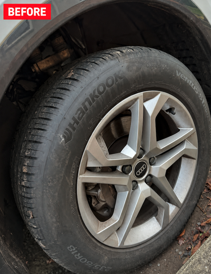 Dirty Audi alloy wheel with brake dust and dull tire sidewall before detail