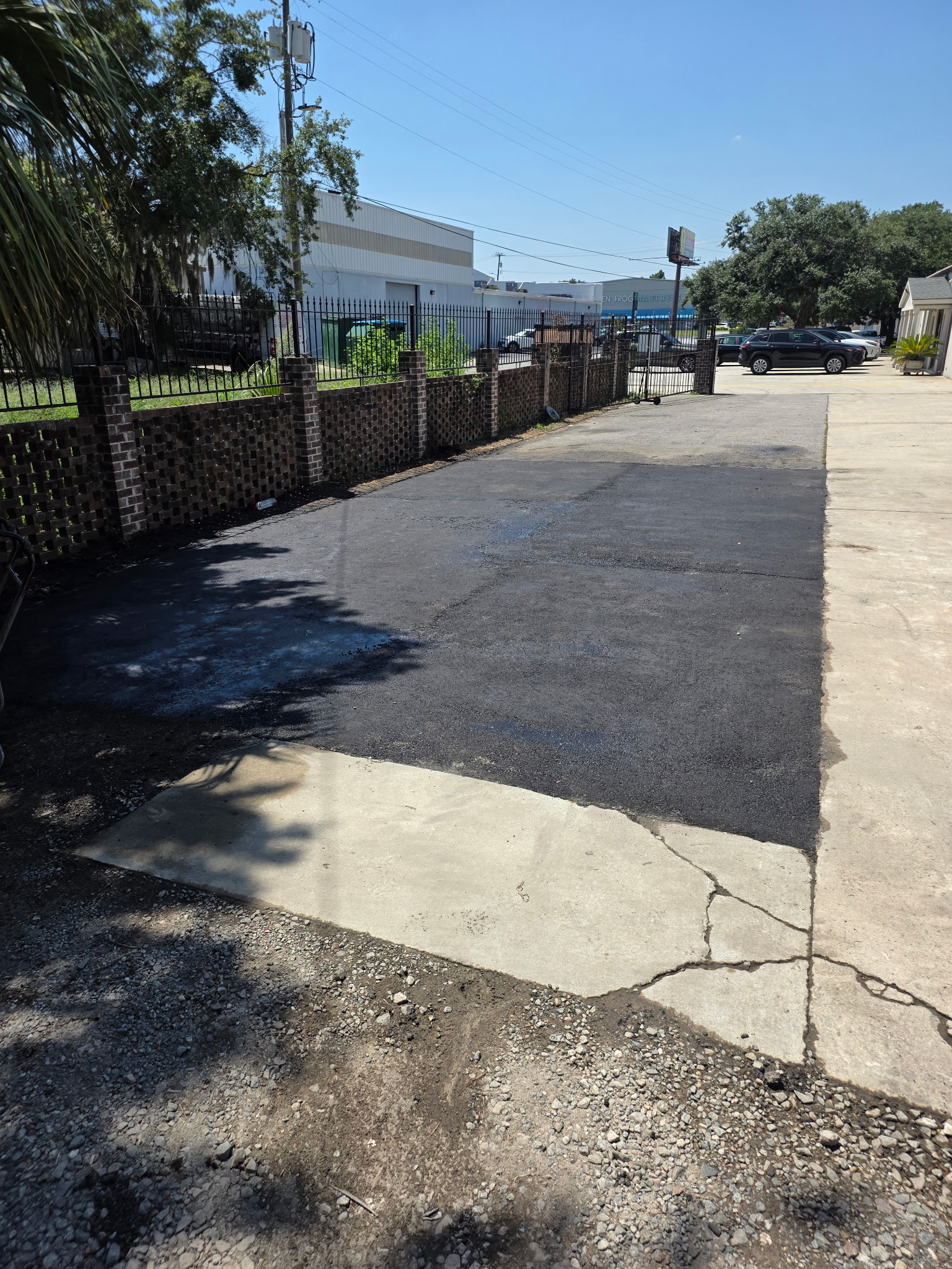 Freshly sealed black asphalt driveway after Coastal Plains treatment