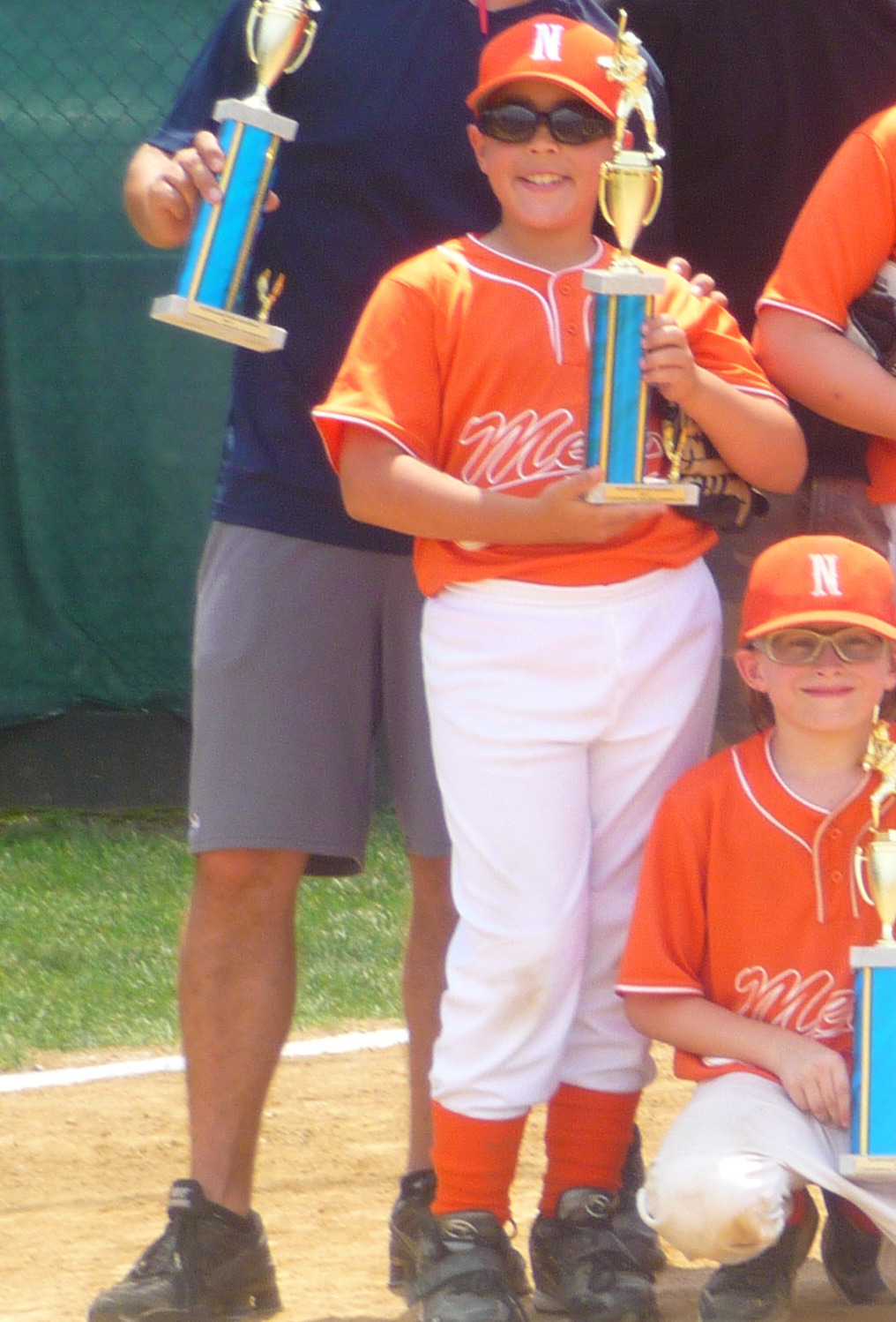Young Michael Smedley smiling with his Little League championship trophy