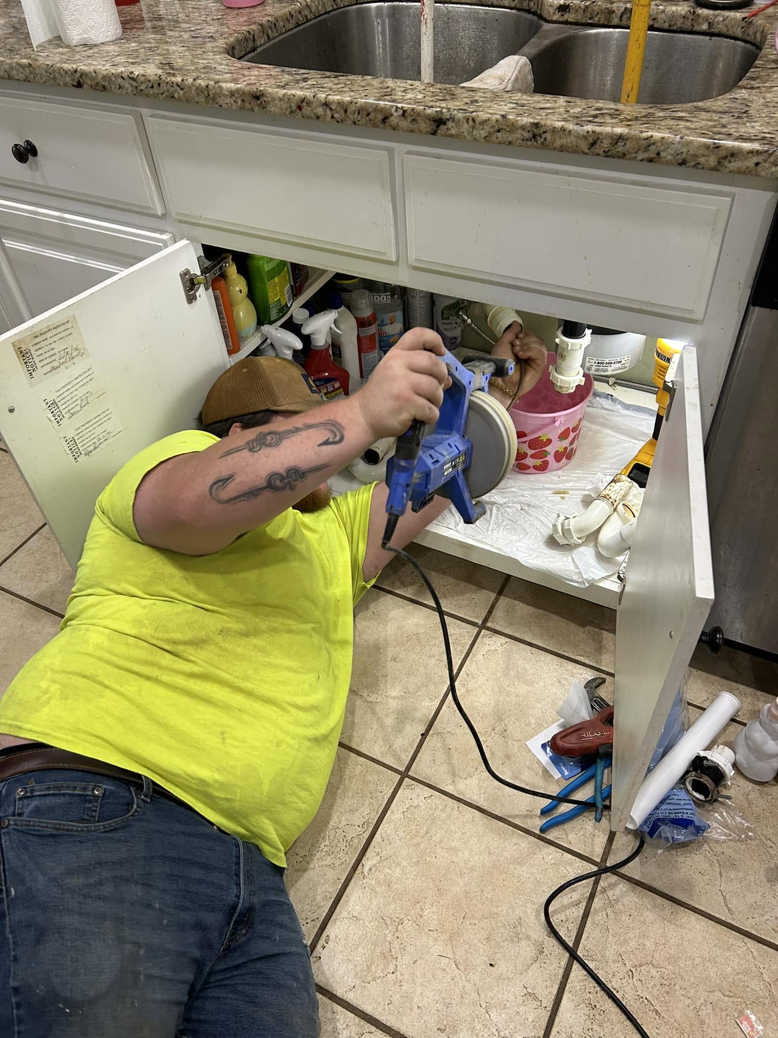 Drain Care LLC plumber repairing a kitchen sink drain line