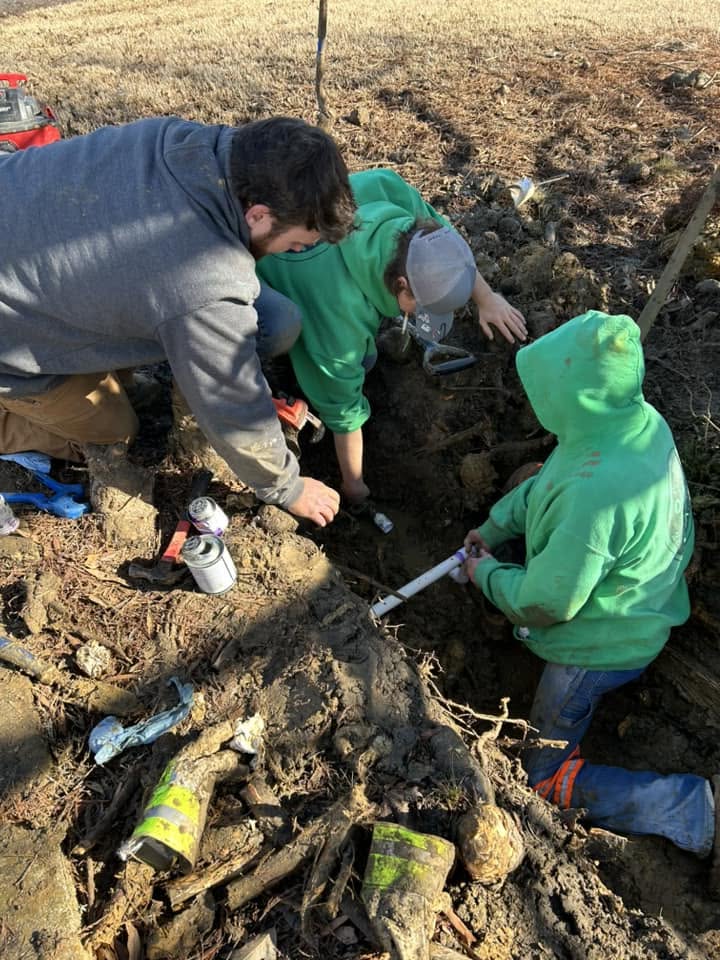Drain Care LLC crew repairing an outdoor sewer line