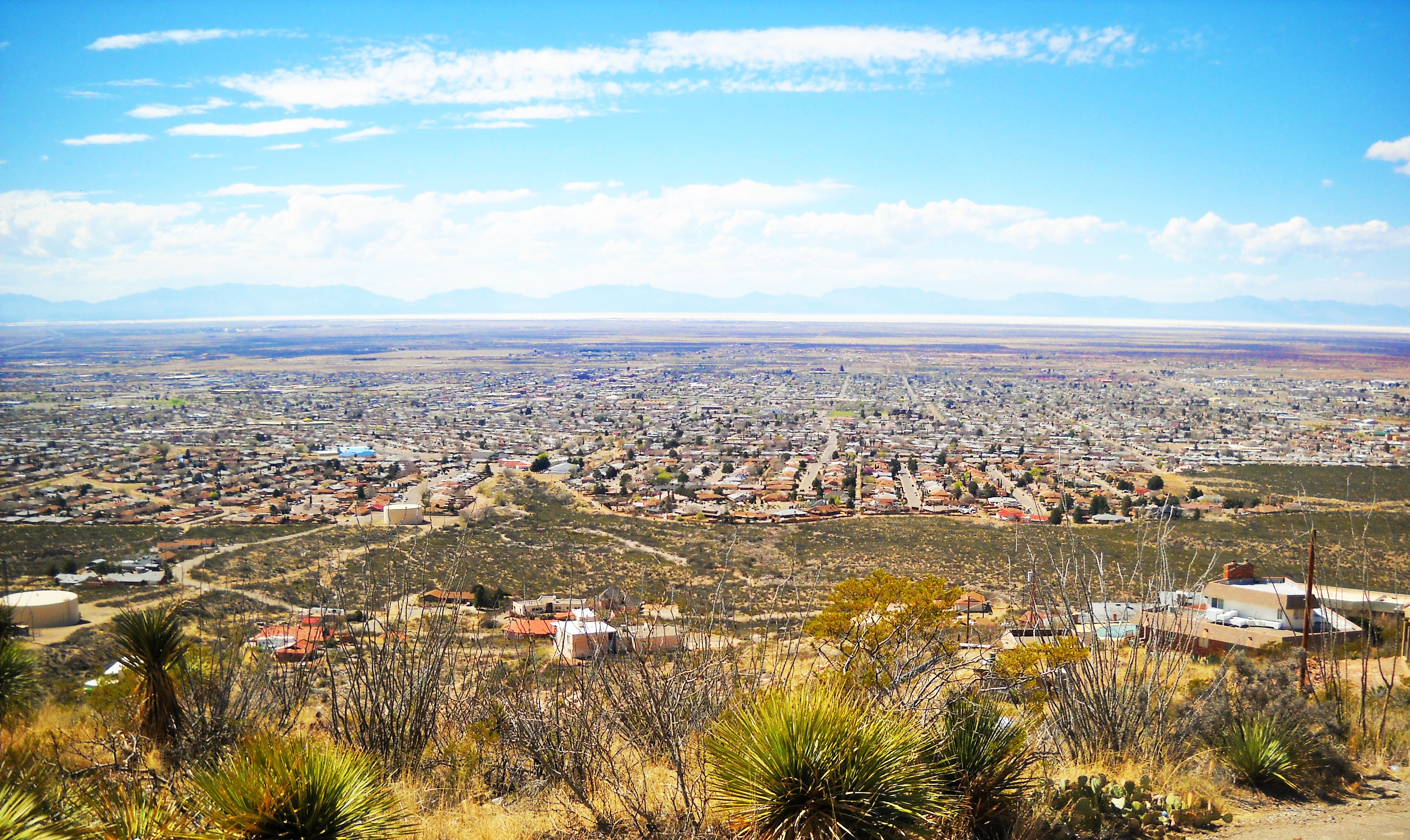 Elevated view over Alamogordo, New Mexico from the eastern foothills, with the white gypsum dunes and the San Andres Mountains on the horizon