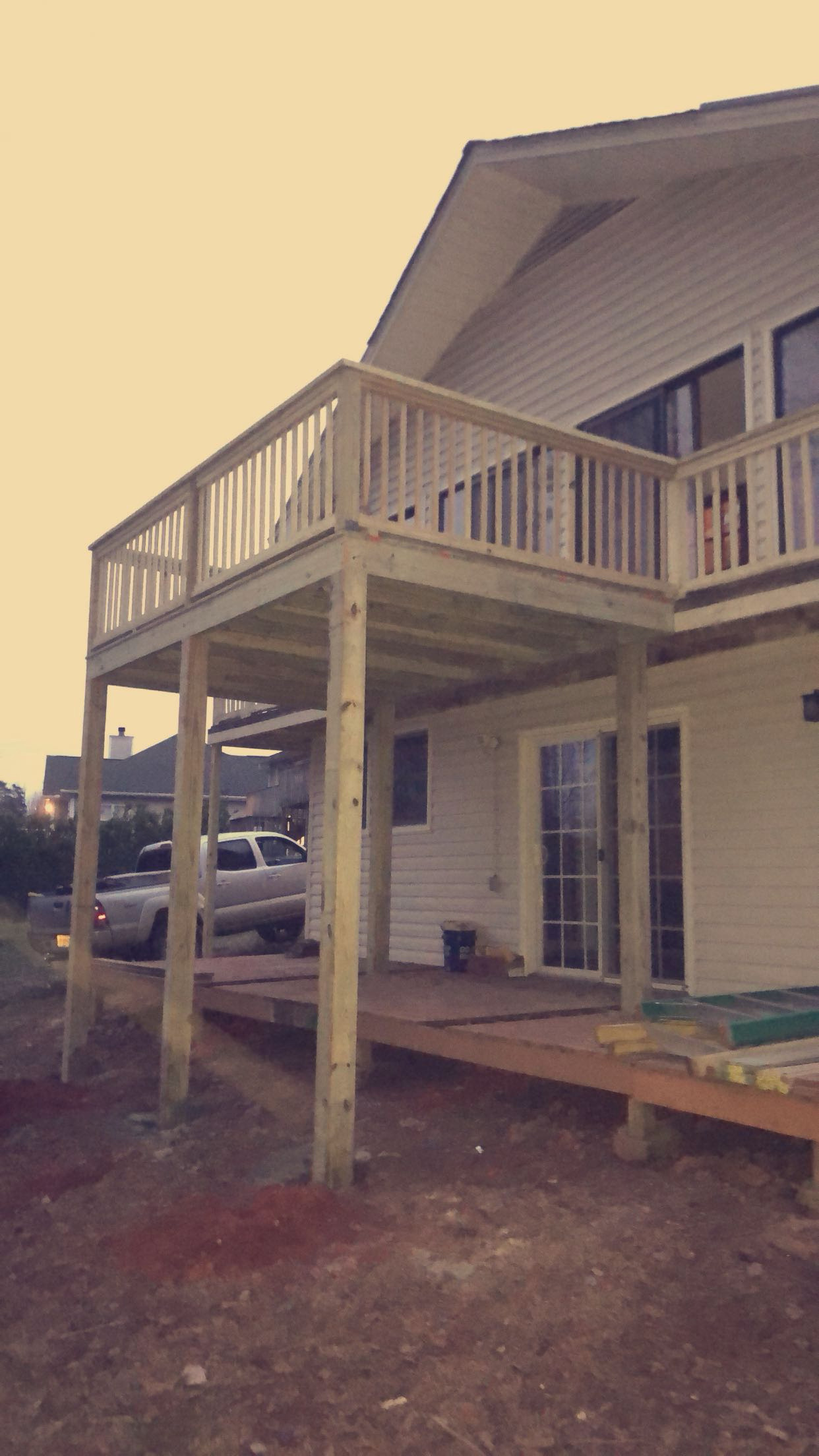 Elevated deck addition with railing by Limitless Construction Services