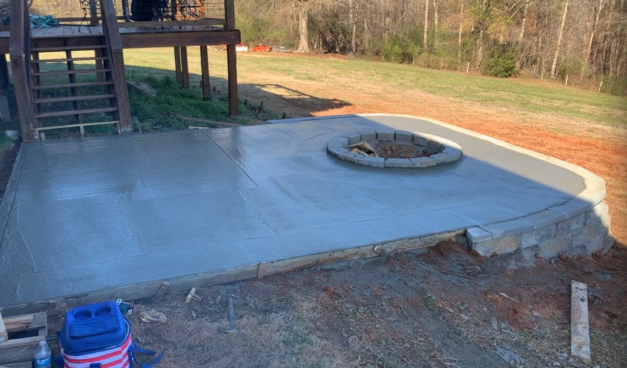 Finished retaining wall, concrete patio, and fire pit by Limitless Construction Services