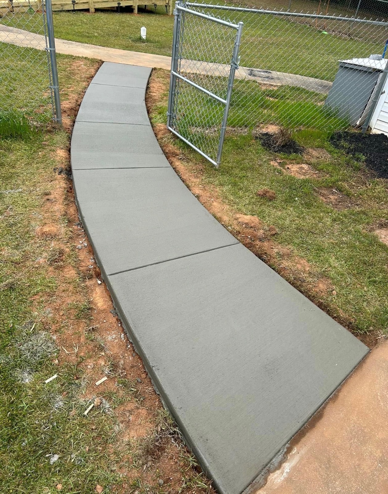Completed curved concrete walkway installation by Limitless Construction Services