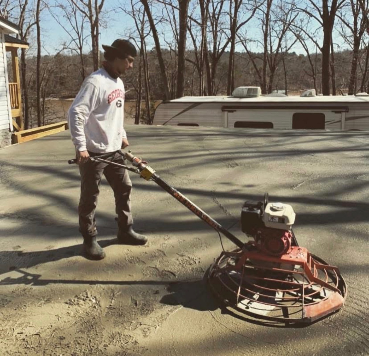 Power trowel finishing work on concrete slab by Limitless Construction Services
