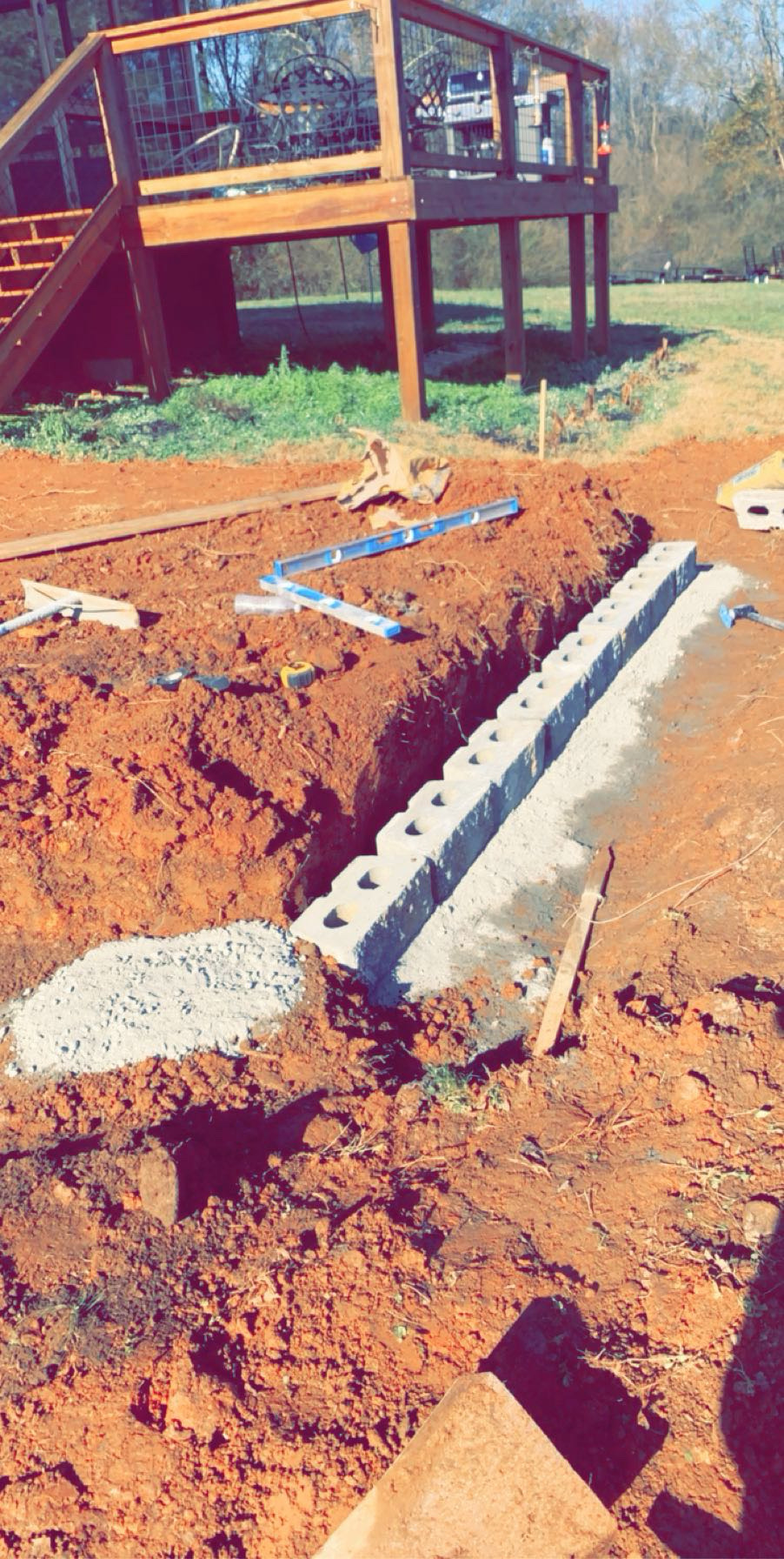 Retaining wall base preparation and block layout by Limitless Construction Services