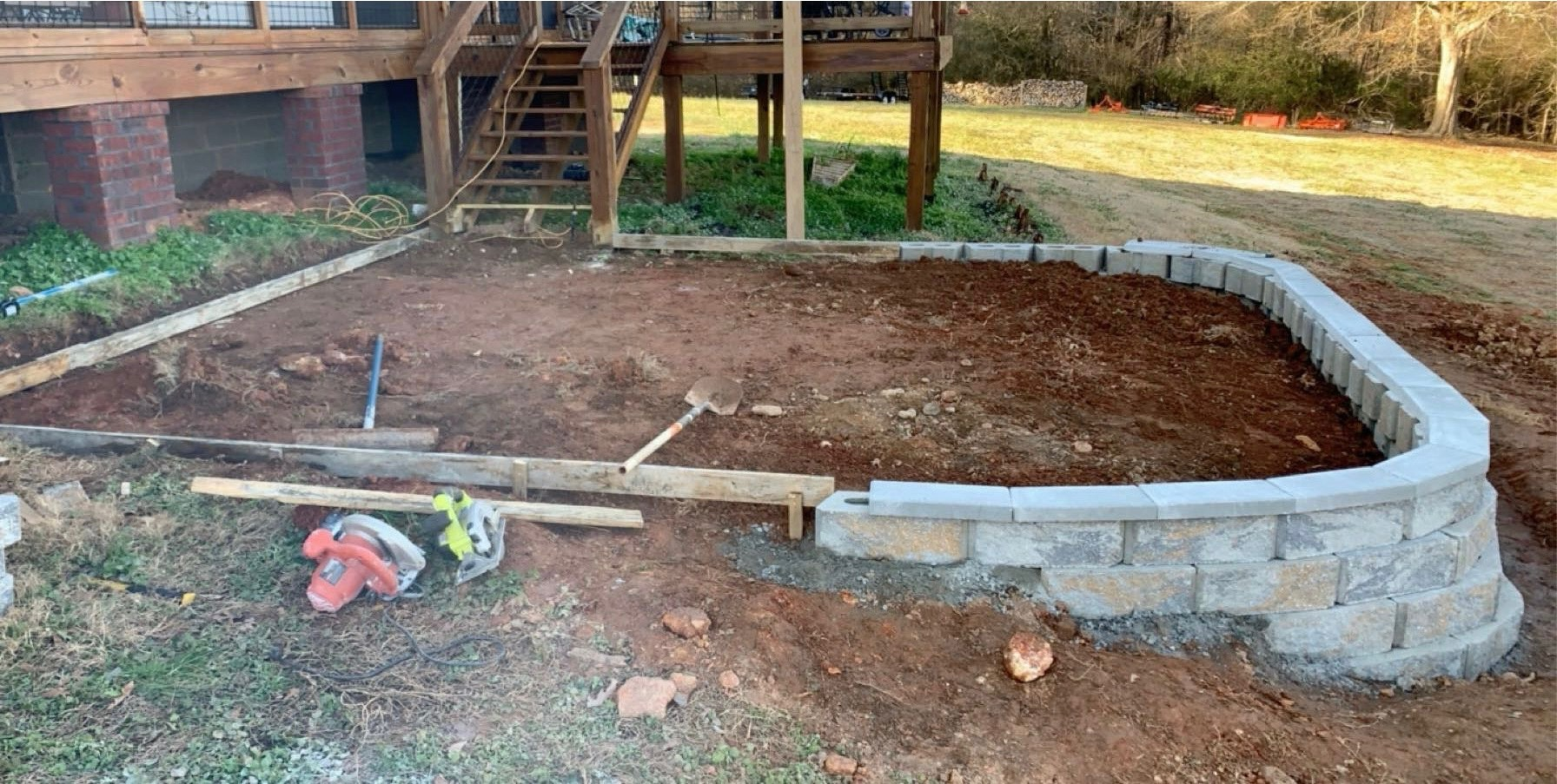 Retaining wall and patio area during construction by Limitless Construction Services
