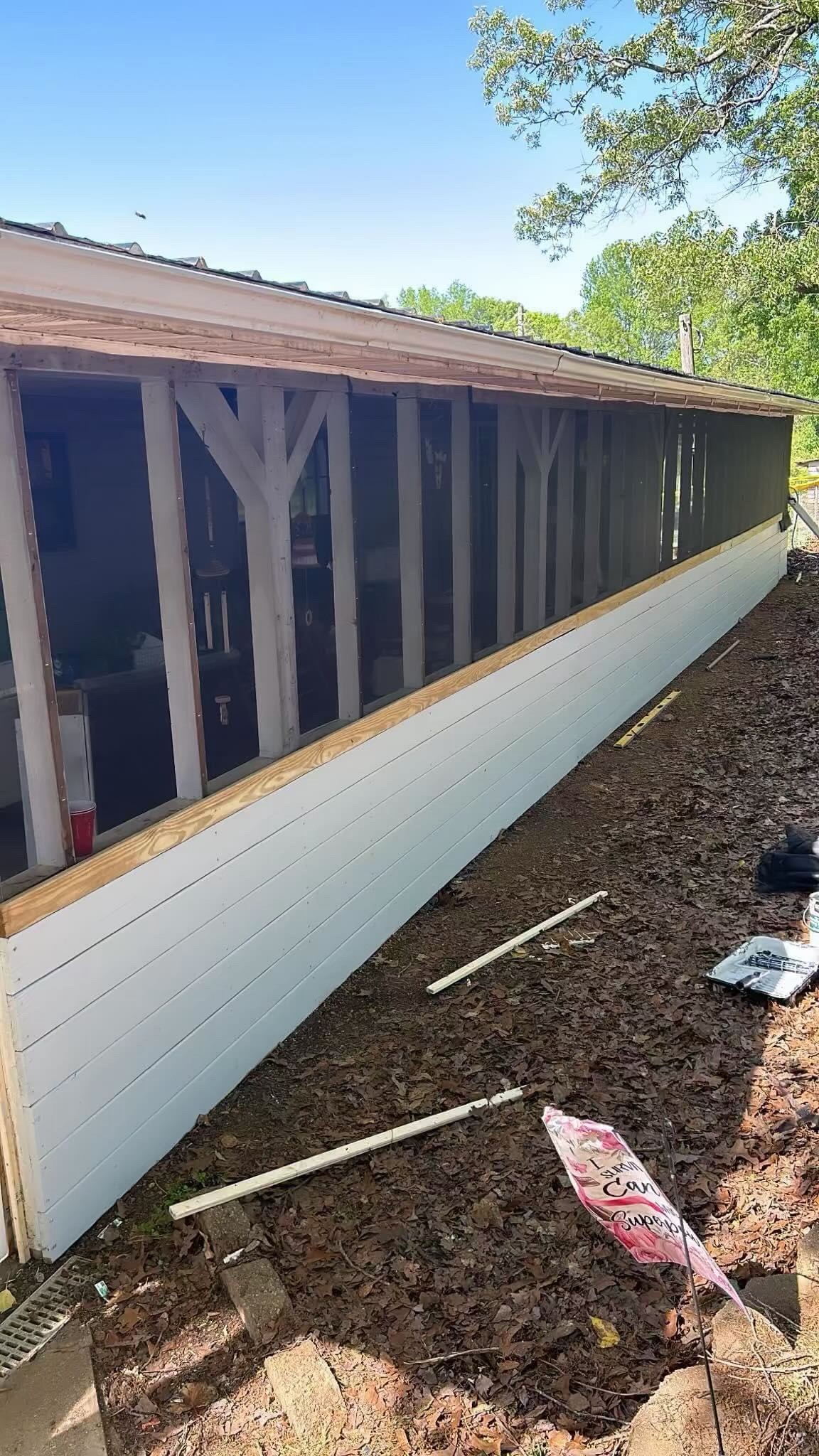 Close-up angle showing clean finished white siding along screened porch wall by Limitless Construction Services