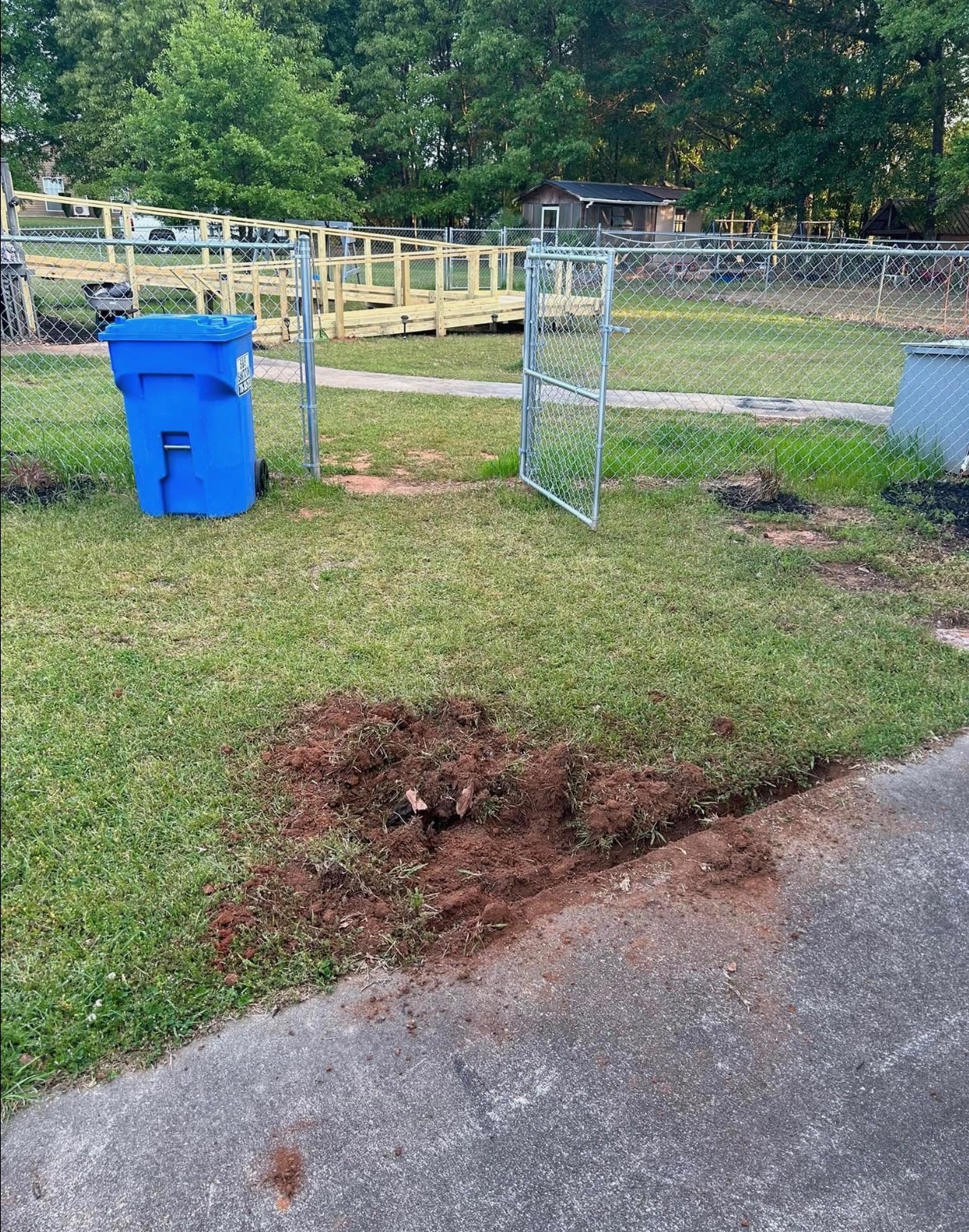 Property yard and gate area before concrete walkway installation by Limitless Construction Services