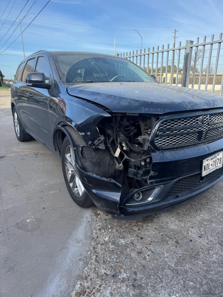 Black Dodge Durango with front-end damage brought in for complete collision repair