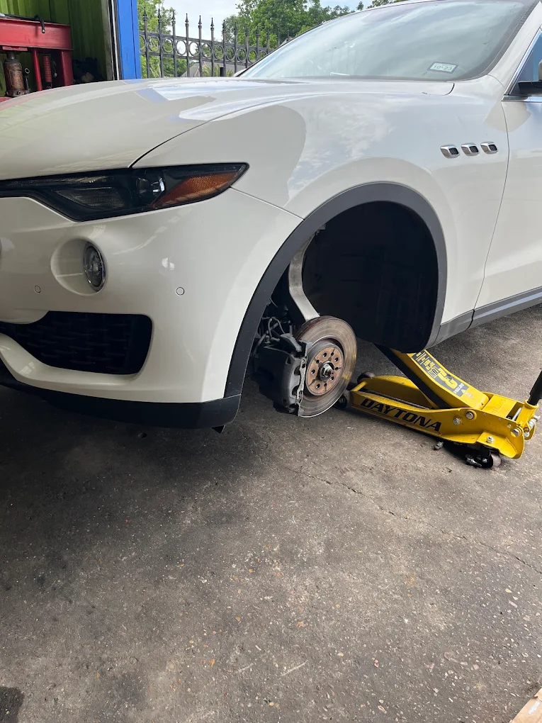 White Maserati Levante on hydraulic jack for high-performance brake and suspension service