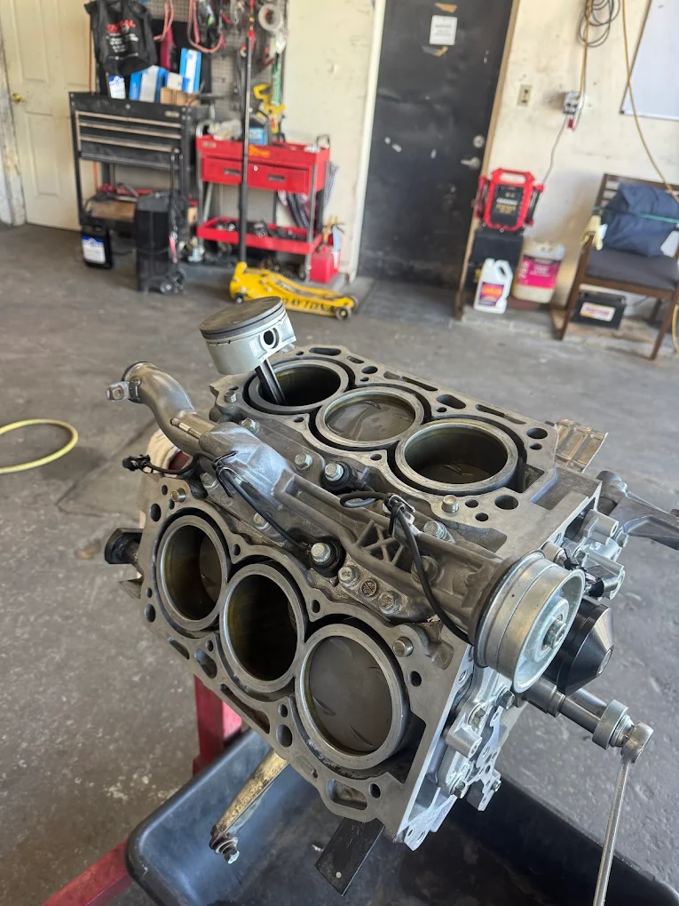 Disassembled V6 engine block on engine stand undergoing mechanical rebuild