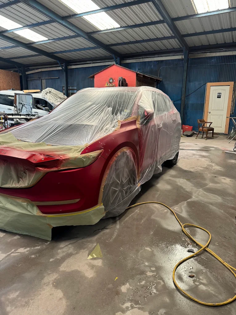 Red SUV meticulously masked and prepped for full custom paint refinishing