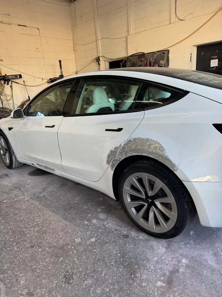 White Tesla Model 3 with quarter panel body filler prep and precision sanding