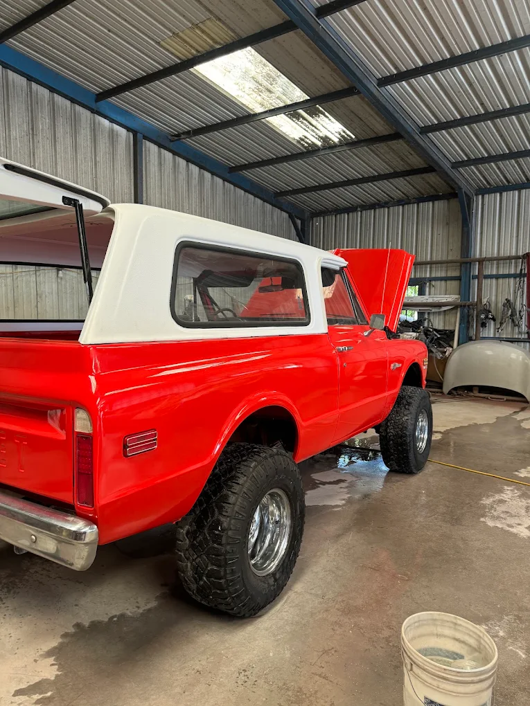 Restored vintage red and white Chevrolet truck inside AZ Auto Repair shop