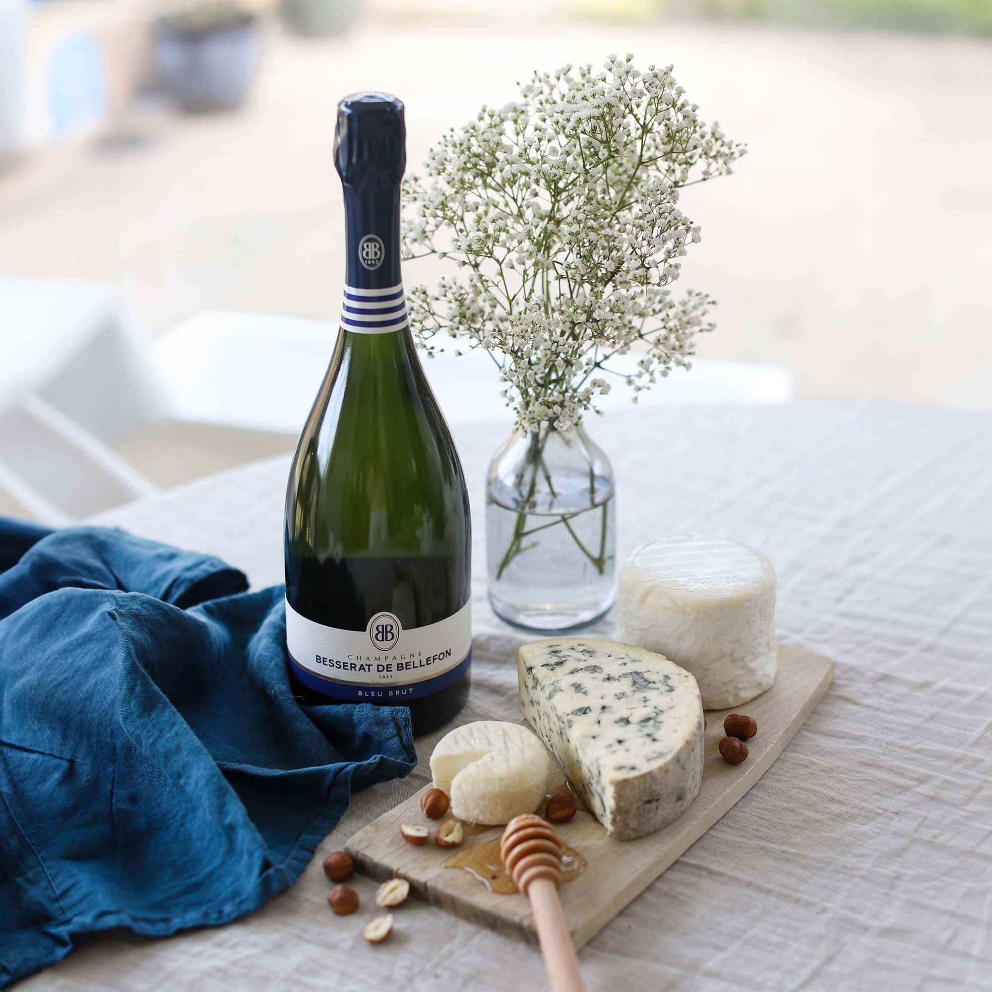 Besserat de Bellefon Bleu Brut presented with a selection of cheeses
