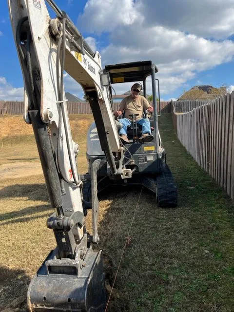 Breaking Ground compact excavator operator excavating on residential property in Augusta, GA