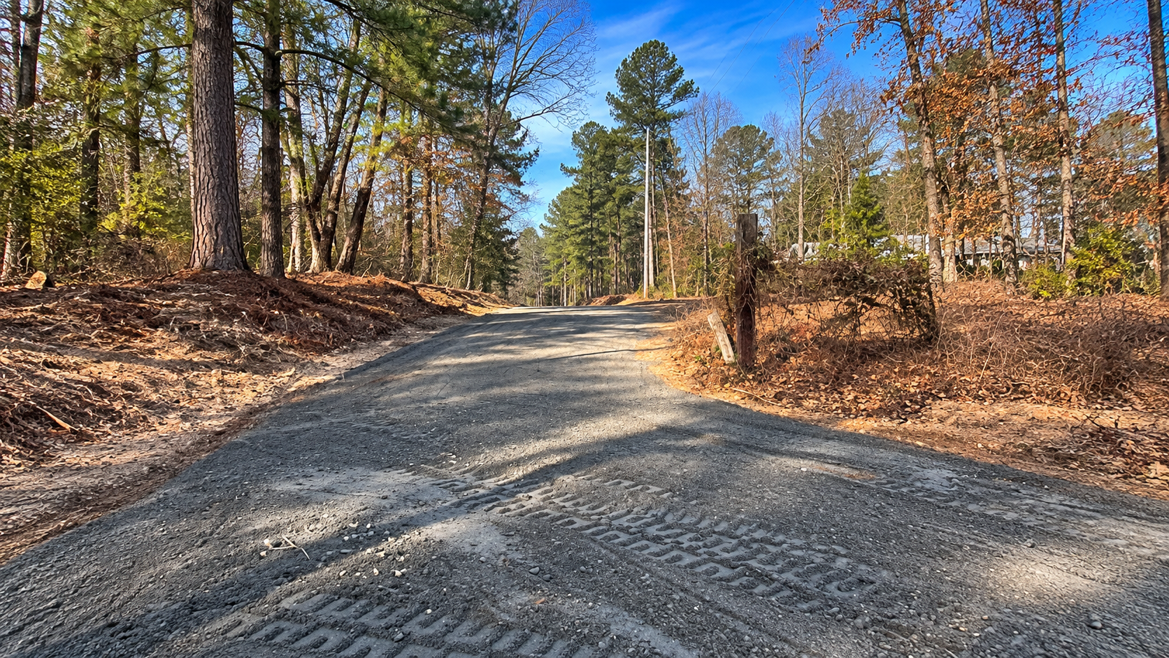 Compacted aggregate driveway with graded shoulders through wooded property in Augusta, GA