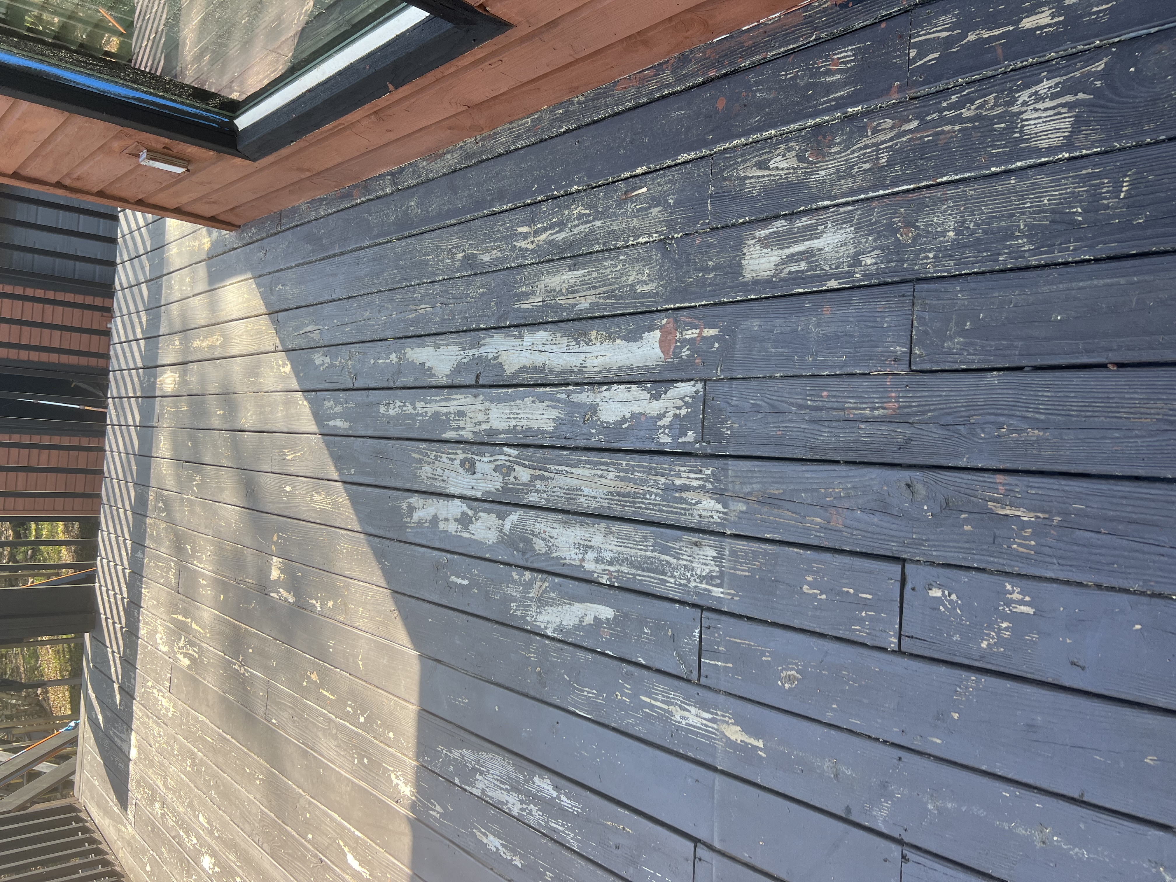 Poconos cabin before renovation — peeling, damaged finish on exterior wood siding