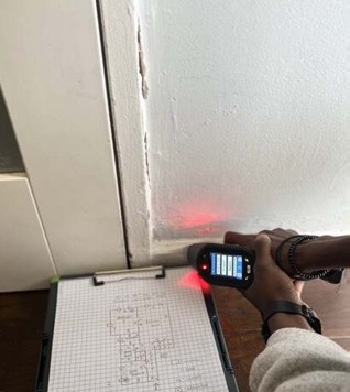 EPA-certified technician performing XRF lead paint testing on a door frame on-site