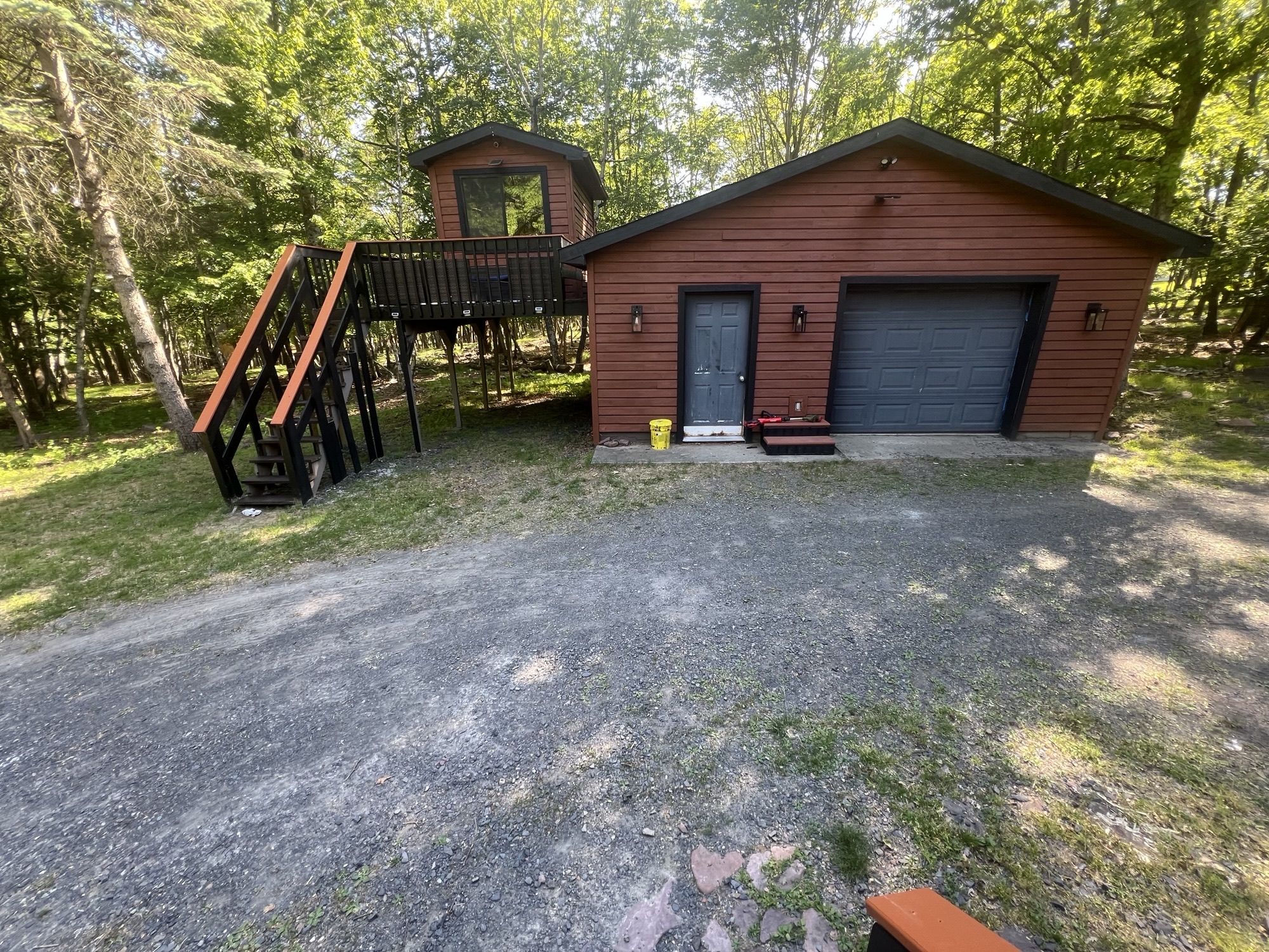 Poconos cabin after renovation — finished garage and elevated treehouse cabin