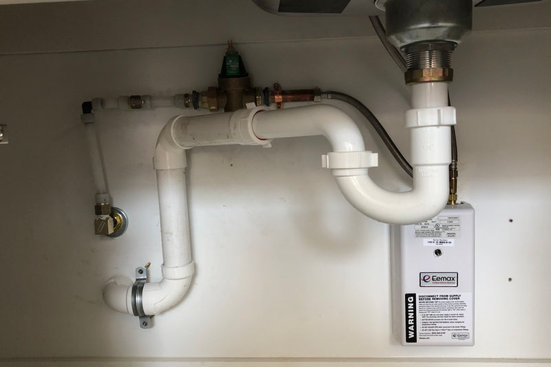 Under-sink plumbing installation in portable office container