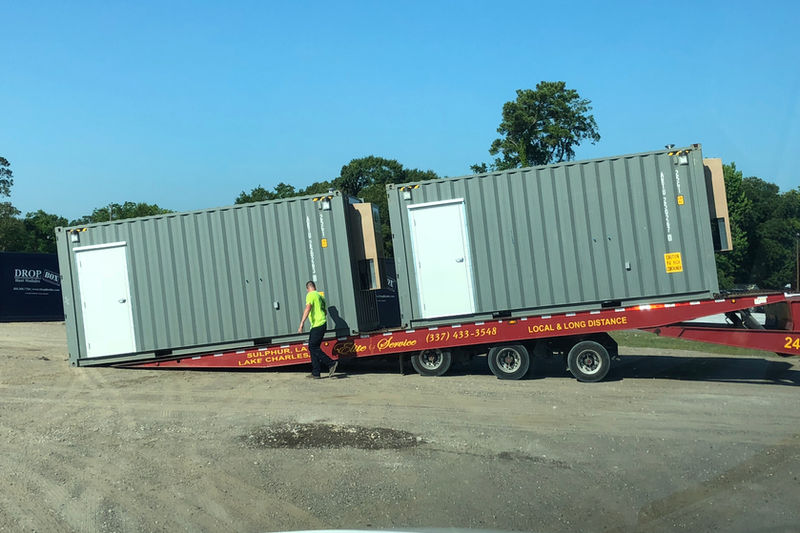 Container loading onto tilt-bed delivery trailer