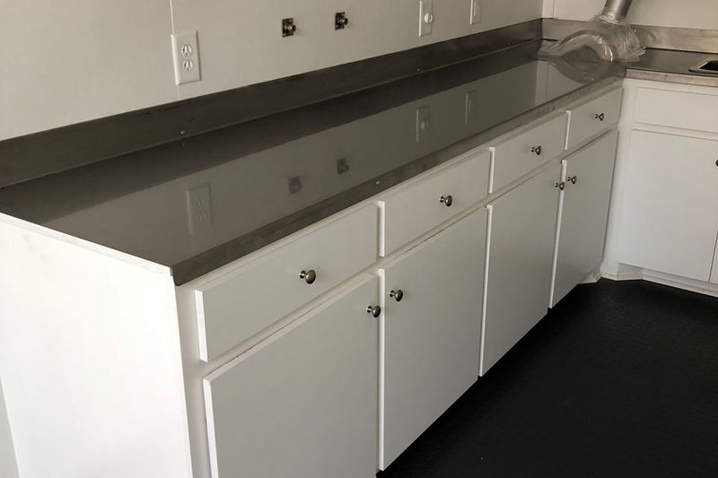 White cabinetry and countertop installation in container mobile office