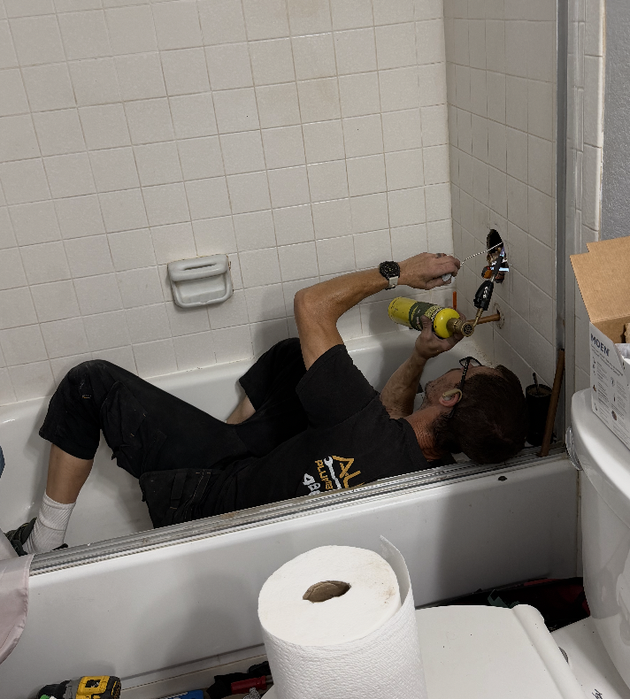 Dave Danberg of Aurora Plumbing soldering a shower valve connection during a bathroom plumbing repair in a Peoria, AZ home