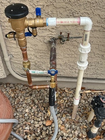 Backflow preventer, shut-off valve, and outdoor plumbing lines installed by Aurora Plumbing in Surprise, AZ