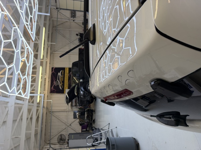 Dent removal process on a car panel at Hail Deals