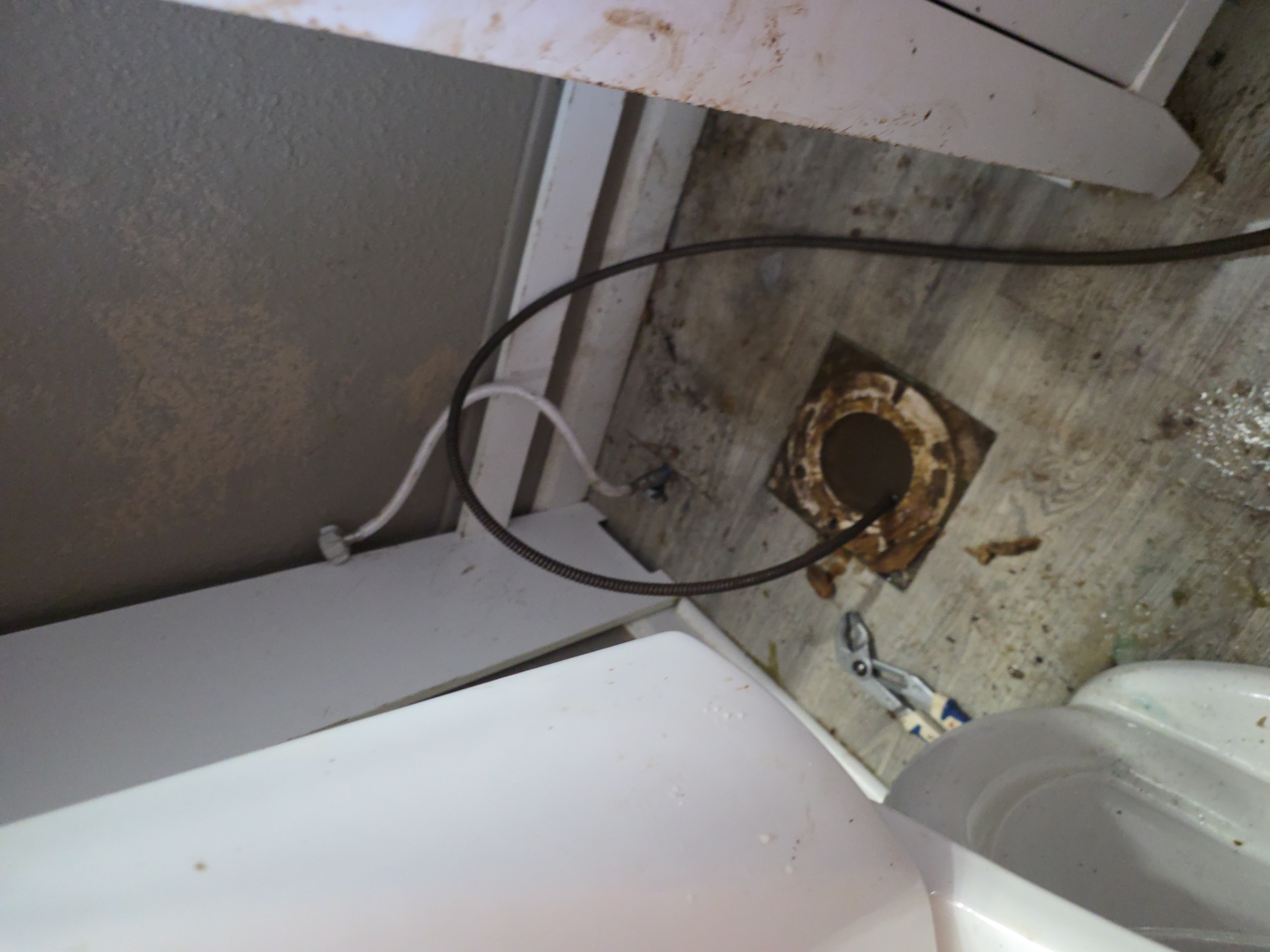 S&K drain cable snaking through toilet drain opening to clear stubborn clog