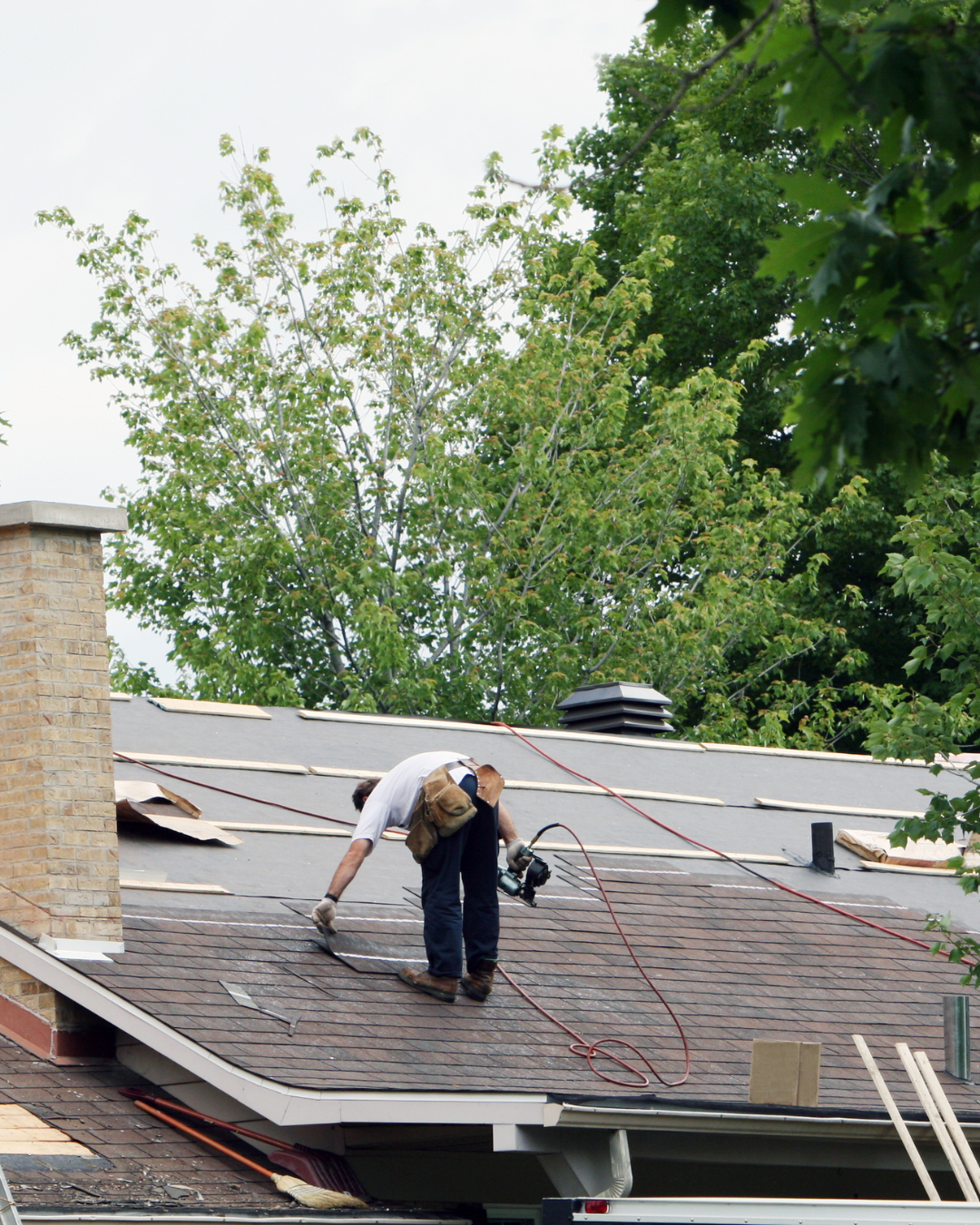 Wide shot of a newly completed, pristine residential roof replacement in a suburban neighborhood
