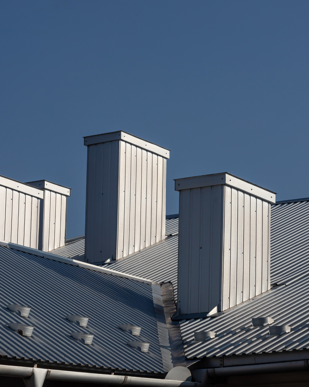 Photo showing maintenance or installation work on a commercial metal or low-slope roof building