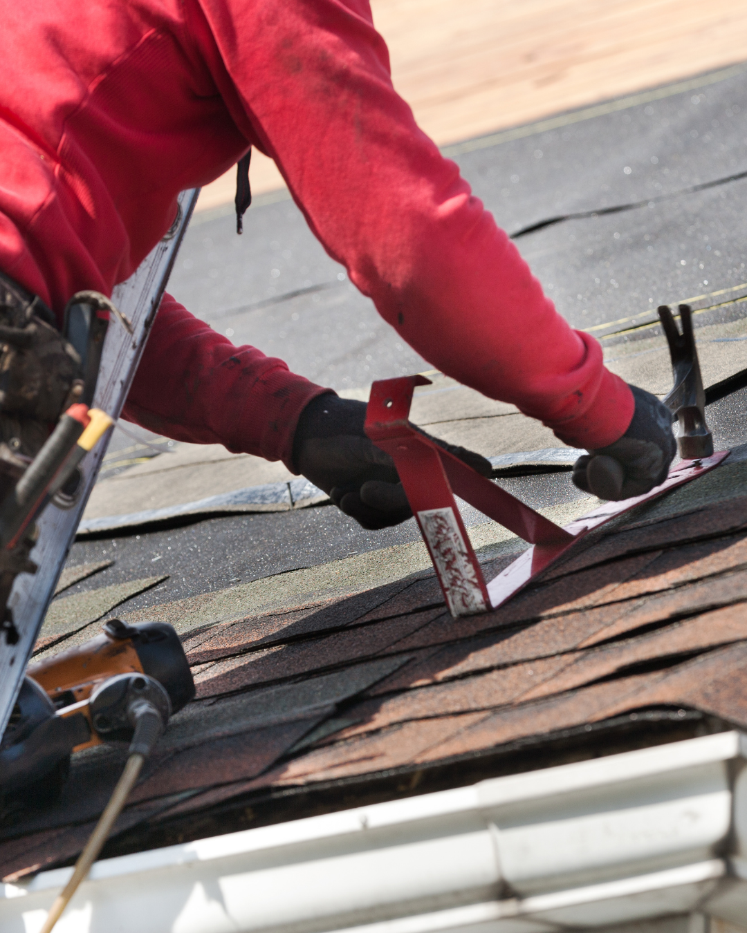 Close-up, professional photo of a roofer repairing shingles or sealing roof flashing