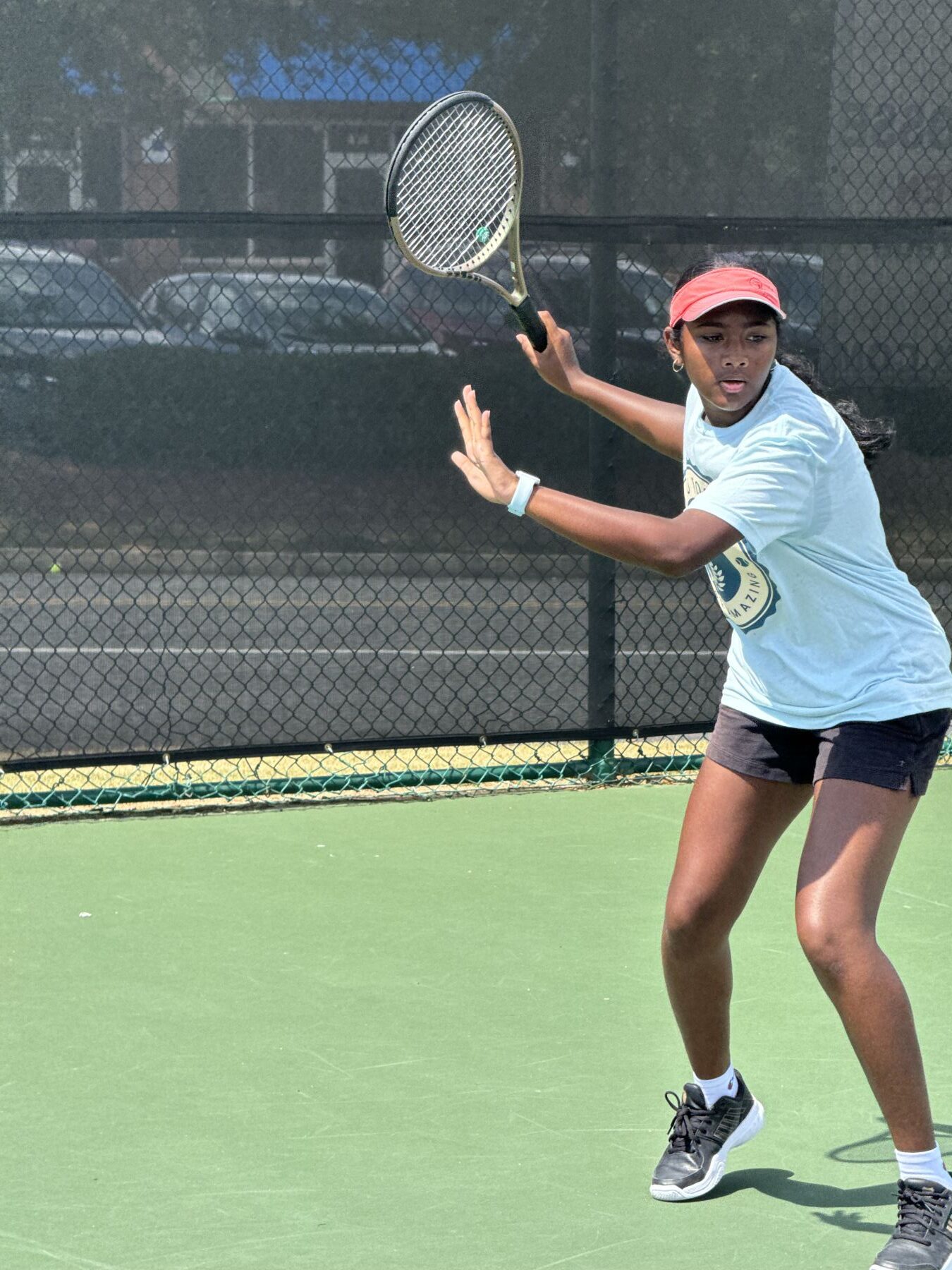Junior player striking a forehand during a tennis drill session