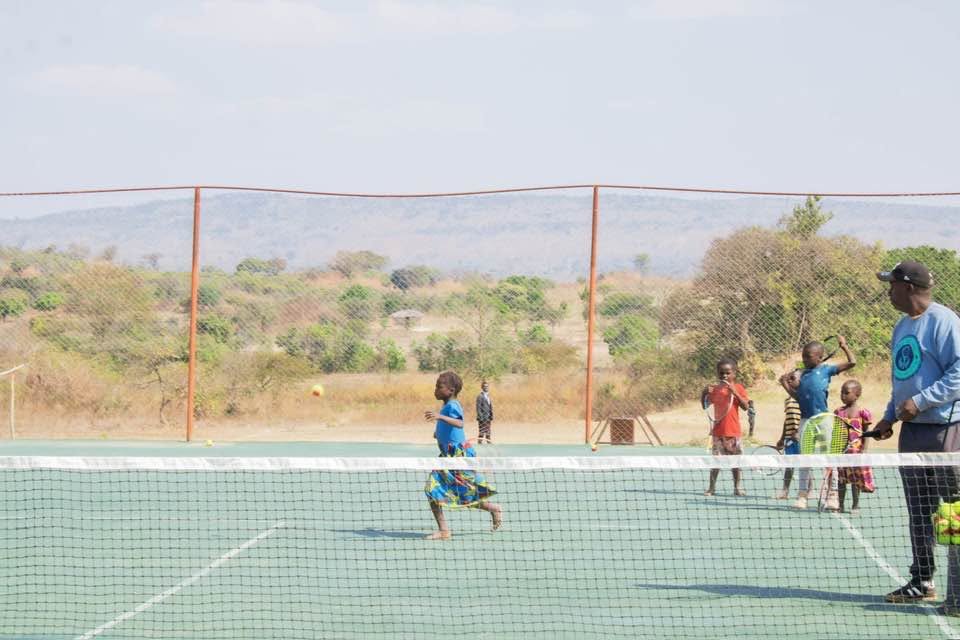 Youth tennis clinic with children practicing on court