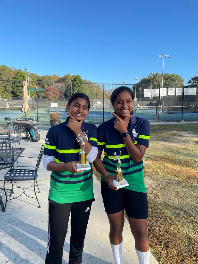 Junior girls displaying tournament trophies