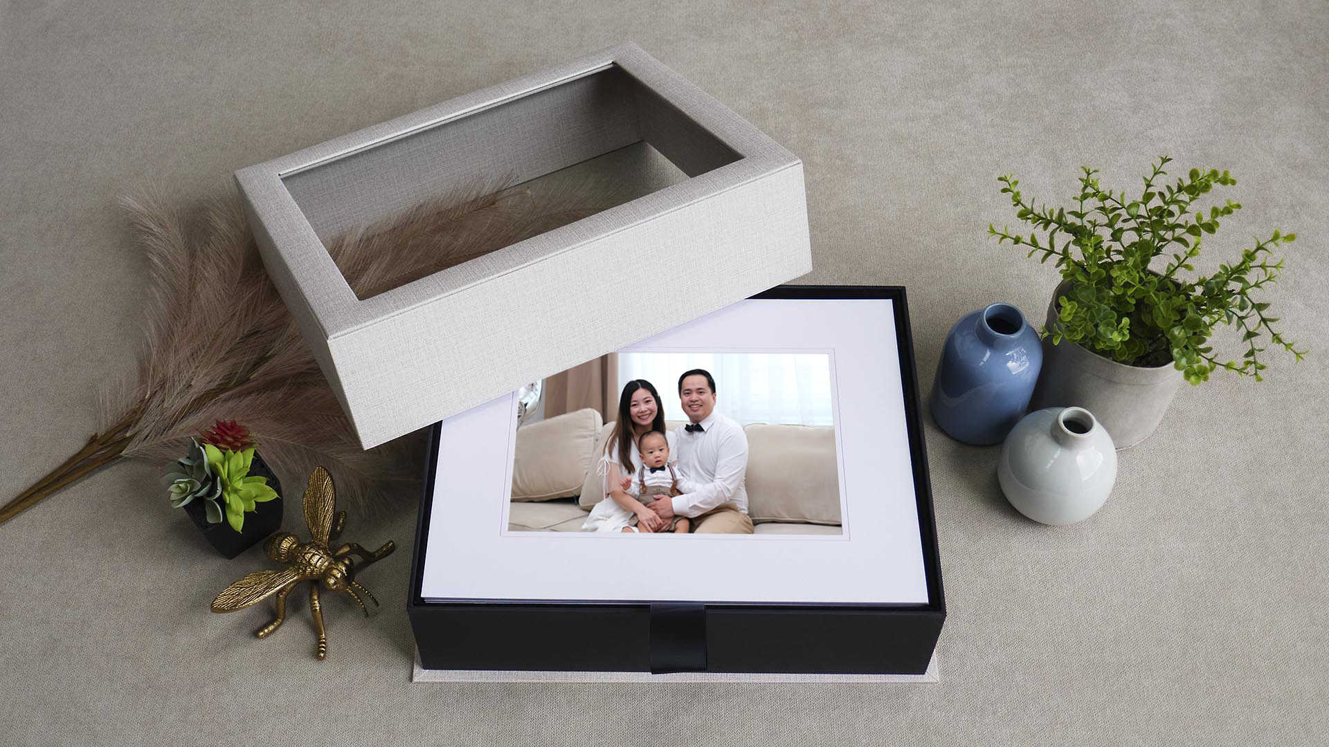 Luxury heirloom folio box revealing a matted fine art portrait of a mother, father, and baby