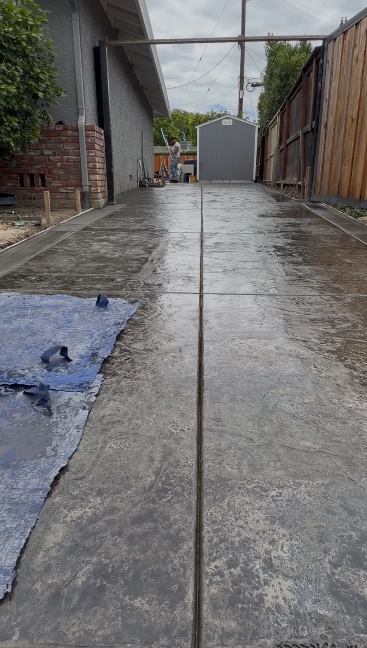 Stamped concrete driveway installation in progress with texture mats and control joints