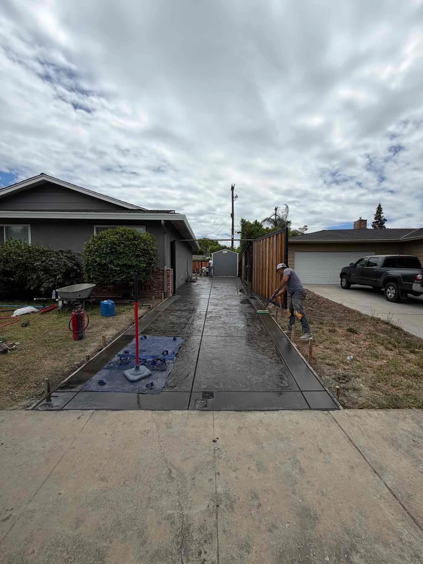 Decorative stamped concrete side driveway installation with smooth borders being finished