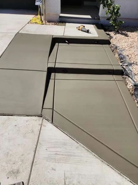 Smooth finished concrete entrance walkway and custom ramp transition with tooled borders