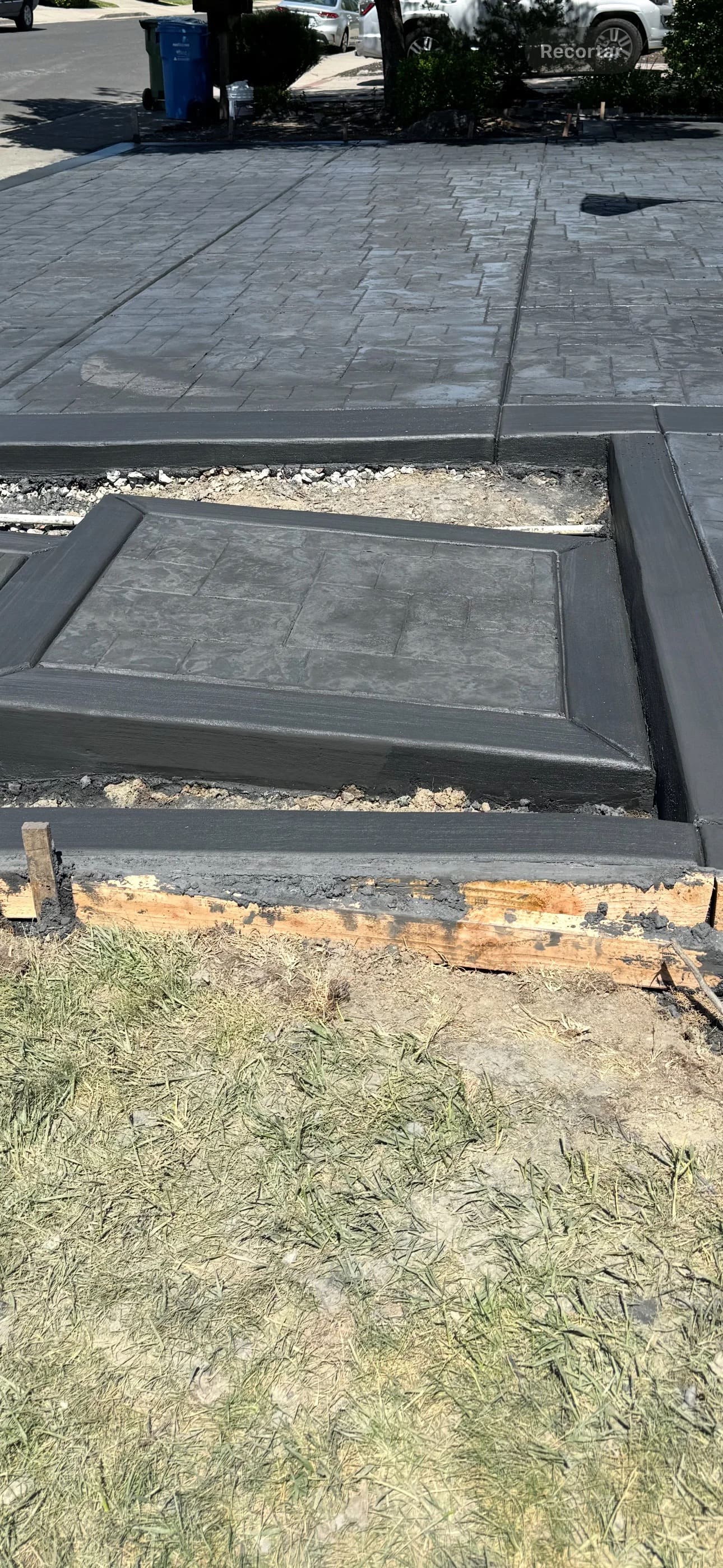 Decorative stamped concrete entryway with bordered curb and steps