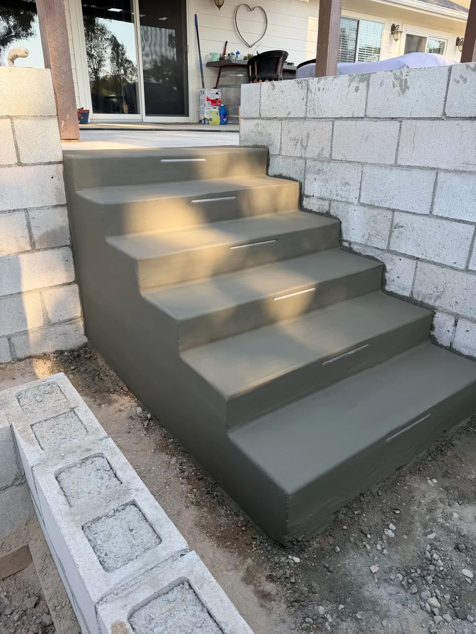 Custom poured concrete steps with integrated step lighting