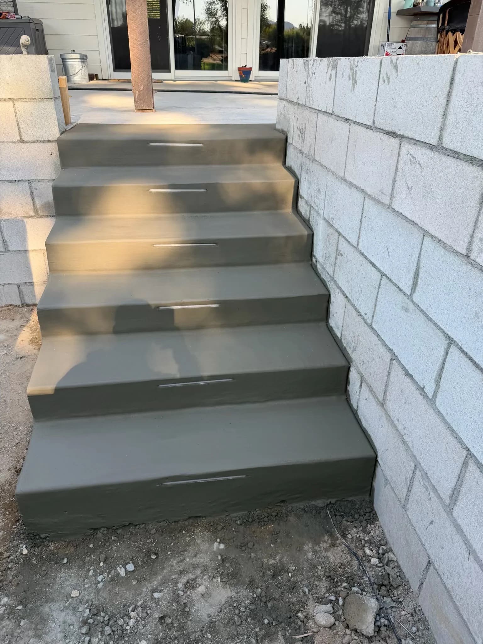 Poured concrete outdoor steps with integrated step lighting between concrete block walls
