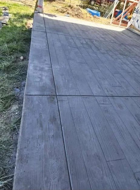 Wood-grain textured stamped concrete patio slab with realistic plank finish