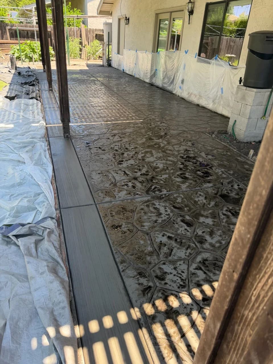 Textured decorative stamped concrete patio with custom slate finish and smooth bordered edge