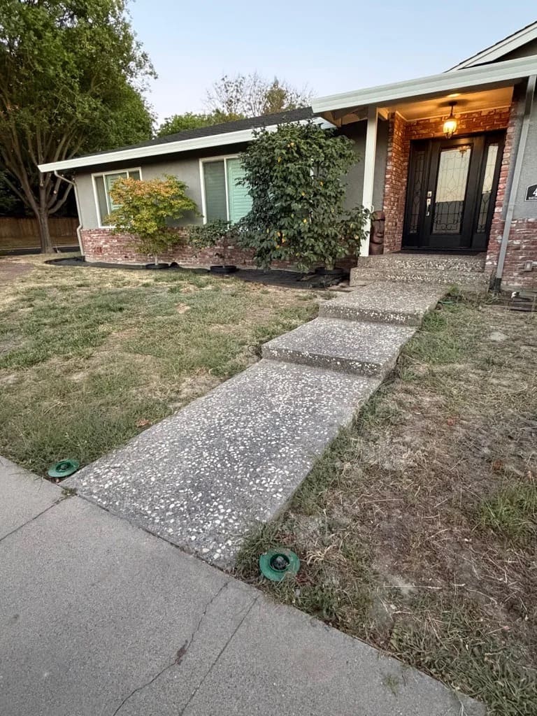 Exposed aggregate concrete front entry walkway and steps leading to residential entrance