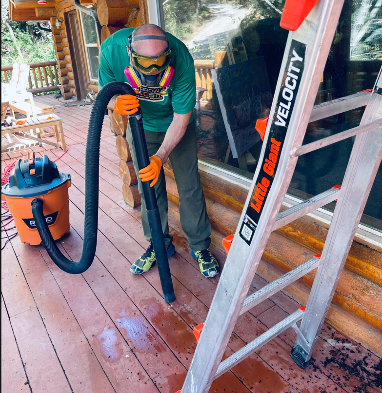 Arrow of Light technician in full PPE and respirator sanitizing and cleaning deck